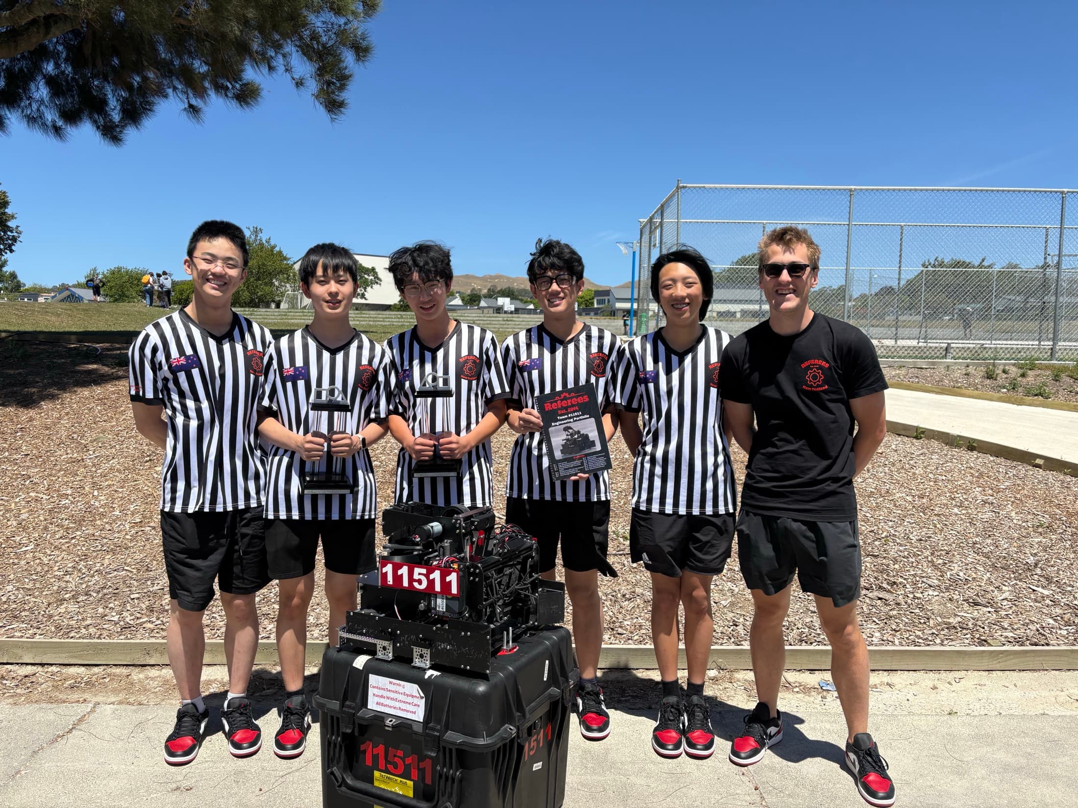 CMR referees celebrating 2025 national championship success with robot and awards